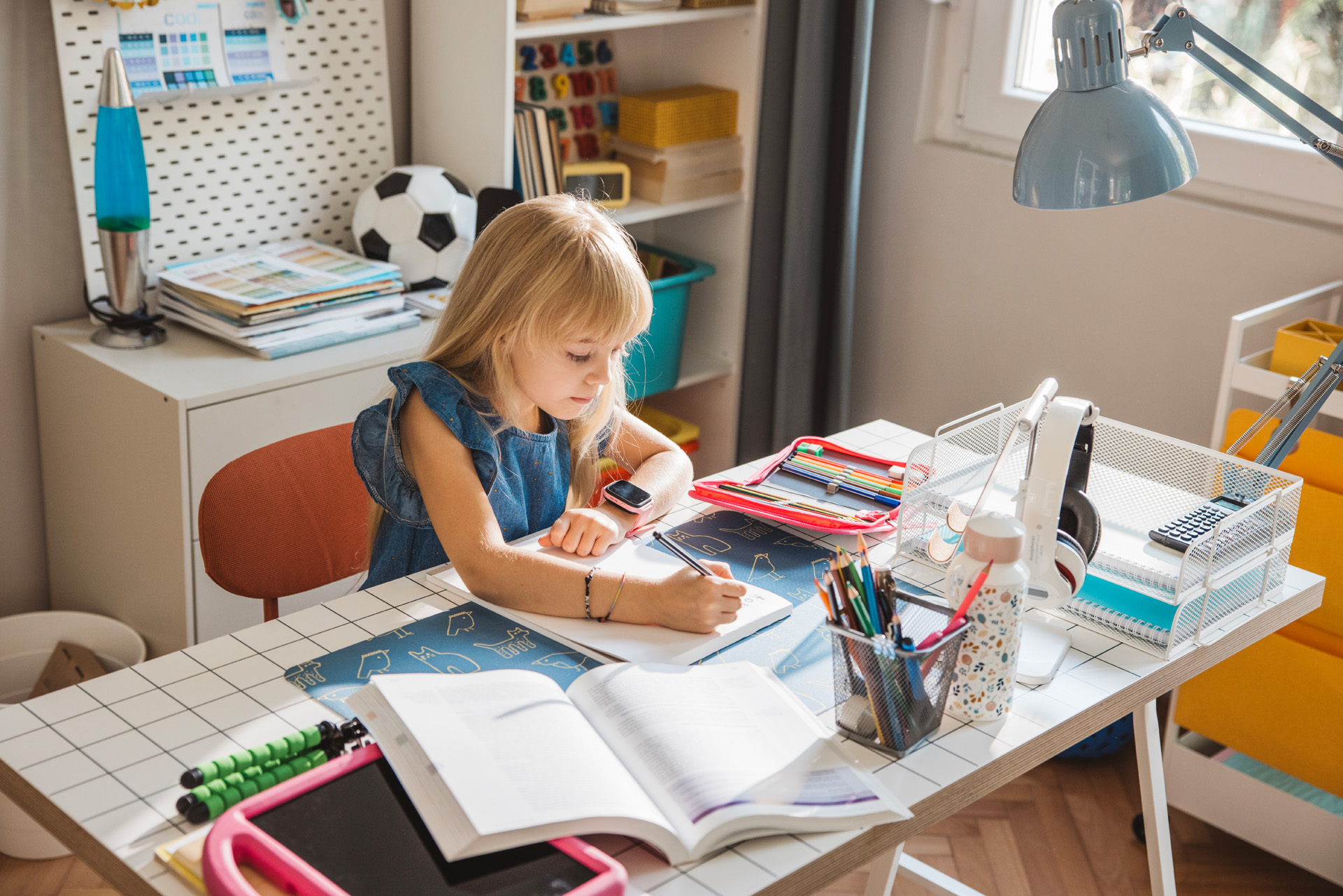 Enfant faisant ses devoirs sur un bureau. Maisons SCLIV.